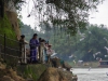 Op de kade staan Vietnamezen in klederdracht te offeren aan de Moeder van het Water