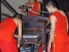 Terwijl binnen de Boeddhisten met een snijmachine bezig zijn