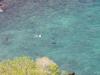 Vanaf de mirador zien we een oosterse jongen achter 2 pijlstaartvissen aan  zwemmen