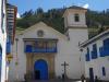 De kerk van Paucartambo; de huizen en de kerk zijn wit gescnhilderd, het houtwerk is blauw
